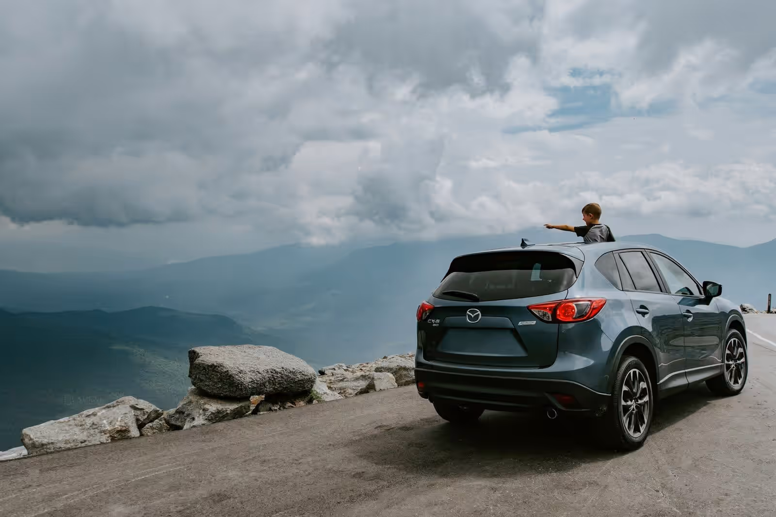An SUV parked at a scenic mountain viewpoint